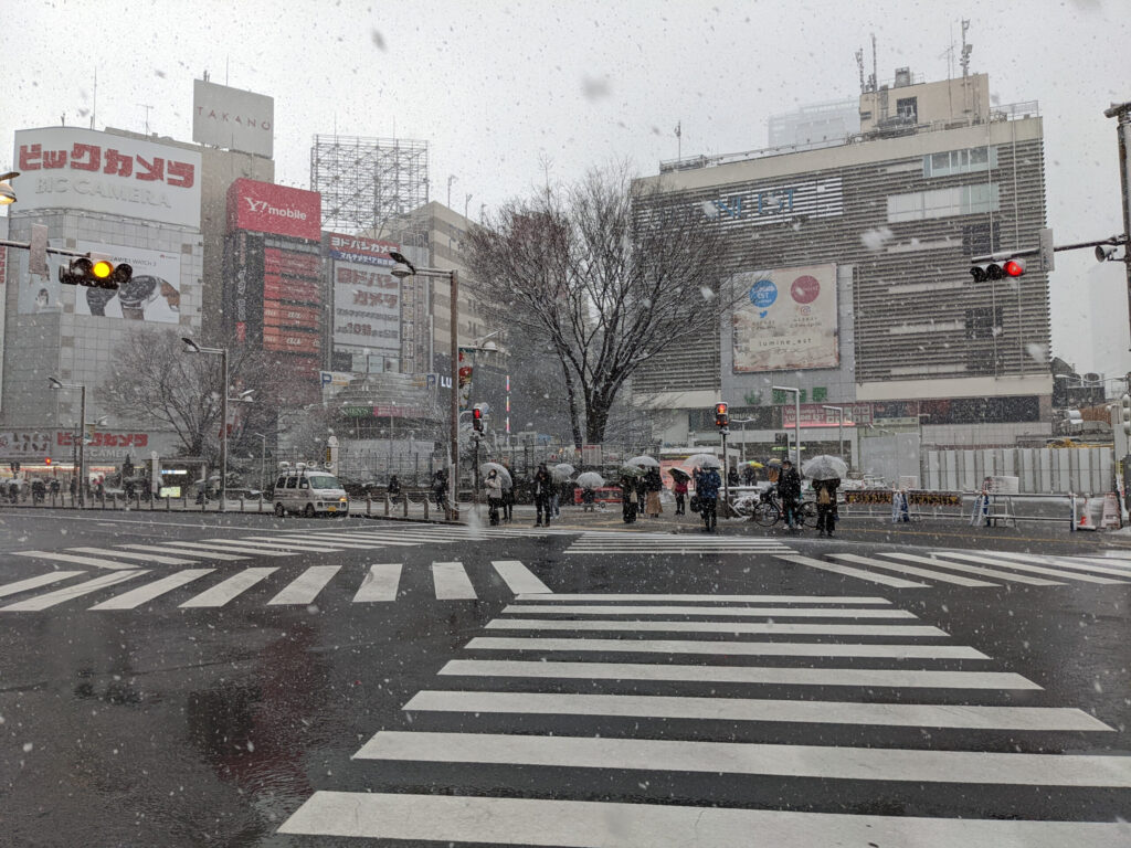 雪の日の新宿 東口アルタ前の交差点